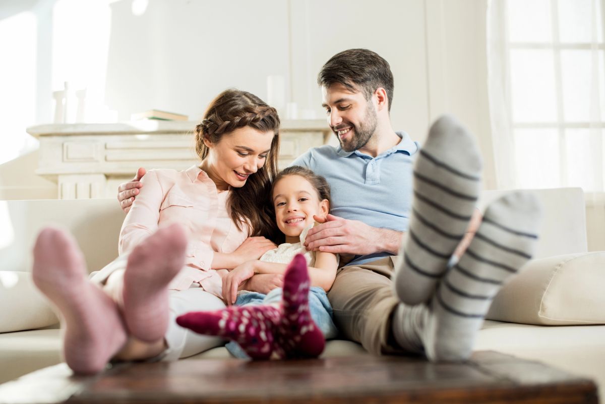 Family sitting on couch in home with Low-Cost Home Insurance in West Babylon, New York